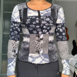 Mönstrad långärmad tröja från Indiska - Säljer en unik och cool långärmad tröja från Indiska. Den har ett mixat mönster med blommiga detaljer och en knappslå framtill. Perfekt för höst och vår, och den är superbekväm att ha på sig. Passar både till vardags och lite mer avslappnade tillfäll