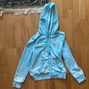 Ljusblå hoodie från Ecko Unltd - Säljer en  ljusblå hoodie från Ecko Unltd. Den har en dragkedja framtill och en stor luva. På ärmen finns det ett  tryck med märkesnamnet. Haha 