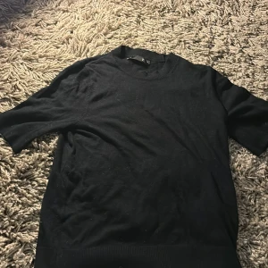 Svart tröja från 157 - Säljer en svart tröja från 157 i storlek XS. Den är i bra skick och har korta ärmar. Perfekt för en casual look eller som lager under en jacka. Materialet känns mjukt och bekvämt. Passar bra till både jeans och kjol.