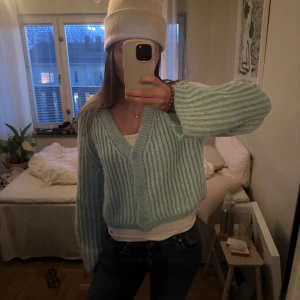 Ljusblå stickad kofta - Superfin ljusblå stickad kofta med v-ringning och knappar framtill. Perfekt för kyliga dagar och ger en mysig känsla. Den har långa ärmar och en skön passform som passar till både jeans och kjol. Ett måste i garderoben för höst och vår!