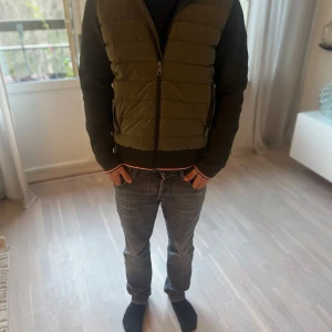 Grön Moncler cardigan med huva - Säljer en snygg grön Moncler cardigan med mörk gröna  ärmar och huva. Jackan har dragkedja framtill och är perfekt för höst och vår. Den är i bra skick och passar både till vardags och lite mer avslappnade tillfällen.