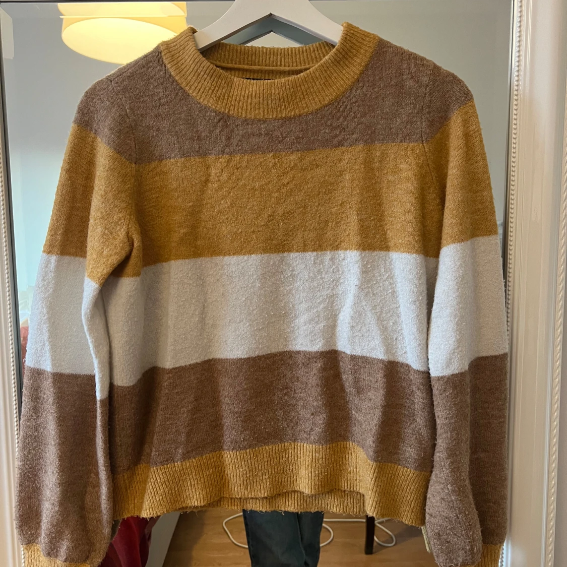 Randig stickad tröja i jordnära toner