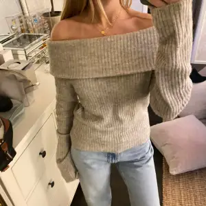 Säljer en trendig superfin beige offshoulder tröja från H&M. Den är stickad och har en ribbad design som ger en snygg look. Perfekt för hösten nu och den kalla vintern. Passar fint med kjol, jeans och kostymbyxor! 