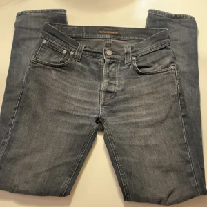 Svarta Nudie Jeans - Säljer ett par snygga svart nudie jeans i modellen Lean Dean och storlek 28:34 men sitter som 28:32. De är i bra skick inga hål eller liknande. De är en svart washed look på dem. Pris kan diskuteras vid snabb affärer.