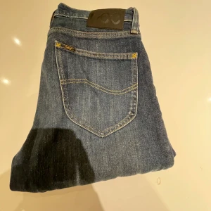 Blå jeans från Lee - Säljer ett par klassiska blå jeans från Lee i modellen Austin. De har en snygg, normal passform och är tillverkade i slitstarkt denim. Perfekta för både vardag och fest! 🕺