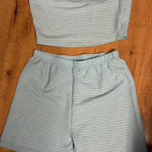 Ljusblå shorts med matchande topp - Säljer ett set med ljusblå shorts och matchande topp. Finns även en kortärmad kofta till 