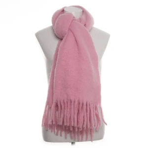 Rosa halsduk från Carin Wester - Säljer en supermjuk och fluffig rosa halsduk från Carin Wester. Den är i ett borstat material som känns riktigt lyxigt och har långa fransar i ändarna. Perfekt för att hålla sig varm och snygg under kyliga dagar. One size passar alla!