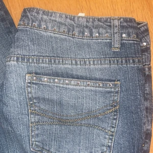 Blå jeans med stenar från Street One - Säljer ett par snygga blå jeans från Street One i storlek 30. De har coola stenar längs fickorna och höften, en klassisk femficksdesign. Perfekta för en casual look eller en utekväll. De är i bra skick och redo för nya äventyr!