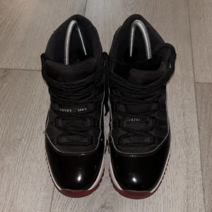 Jordan 11 bred - Säljer ett par snygga Jordan 11. Skorna har en glansig finish och klassisk snörning. Perfekta för både vardag, fest och även basket! De är i bra skick och redo för nya äventyr. Använd 5-6 gånger.