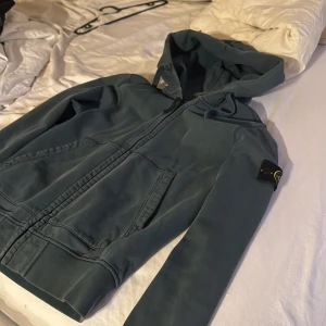 Grön zip hoodie från Stone Island - Säljer en snygg grön huvtröja från Stone Island. Hoodien är i bra skick men finns täcken på blekningar på vissa ställen, annars väldigt snygg och skön! Bara att höra av dig vid frågor! 🥂
