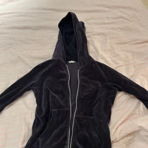 Mjuk mörkblå hoodie - Säljer en supermjuk och skön mörkblå hoodie i velourmaterial. Perfekt för mysiga dagar hemma eller som ett extra lager under jackan. Den har en dragkedja framtill och en praktisk huva. Passar perfekt för höst och vinter! Säljs för jag inte använder, endast använd 2 gånger.