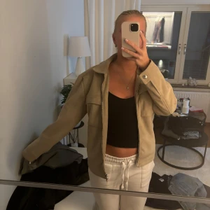 Beige mockajacka från Rick Vegan Suede - Säljer en snygg beige mockajacka från Rick Vegan Suede i storlek S. Jackan har en klassisk krage och långa ärmar, perfekt för höst och vår. Den är i mycket bra skick och passar till både vardag och fest! Nypris 1200kr