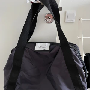 Day et väska - Day et väska i mycket bra skick, som ny. Färgen är mörklila.   Mått: Bredd ca 40 cm Höjd ca 35 cm utan band Djup ca 15 cm