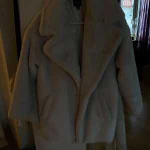 Beige teddyjacka - Mysig beige teddyjacka från Boohoo, jackan har en oversized passform och långa ärmar. Den har en klassisk krage och stängs med band framtill.