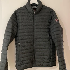 Grön dunjacka från Colmar - En riktigt snygg mörkgrön dunjacka i stl 48 (s/m) från Colmar i bra skick. Riktigt snygg i färgen: botanical light steel (mörkgrön). Inköpt våren 2022 och varsamt använt. Finns en liten reva vänsteraxel (bild 2) men inget som sticker ut. Säljs på grund av att jackan är för liten i storleken. 