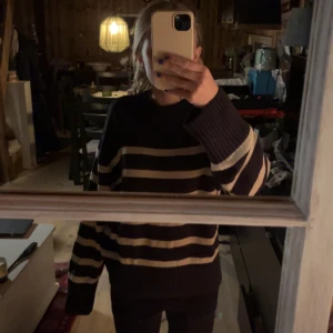 Randig stickad tröja från Gina Tricot - Säljer en supermysig svart och vit randig stickad tröja från Gina Tricot. Perfekt för kyliga dagar med sin varma och bekväma passform. Tröjan har långa ärmar och en klassisk rund halsringning. Passar perfekt till både jeans och kjol! 💕💕