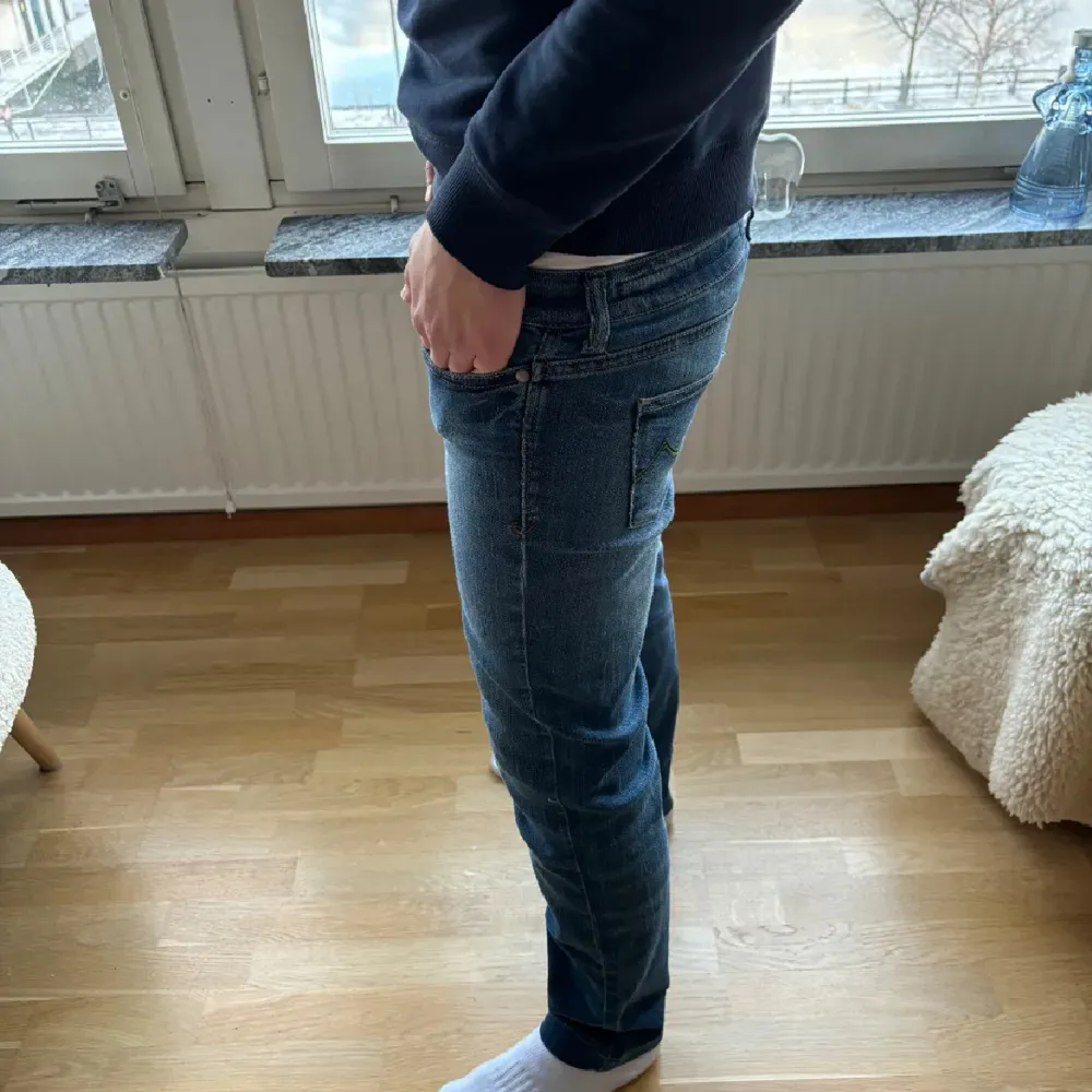 Säljer ett par snygga blå jeans från Jacob Cohen. De har en slim passform och är i mycket bra skick. Perfekta för både vardag och fest! Jeansmaterialet är av hög kvalitet och de har en klassisk design med knappar och dragkedja.. Jeans & Byxor.