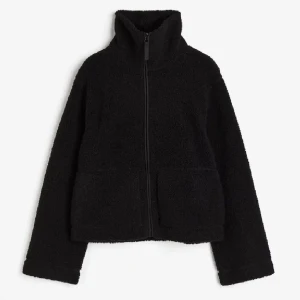 Svart teddyjacka med dragkedja - Mysig svart teddyjacka i mycket bra skick. Perfekt för höst och vinter med sin varma och fluffiga design. Jackan har en dragkedja framtill och långa ärmar, vilket gör den både praktisk och stilren. Passar perfekt för en casual look eller när du vill hålla dig varm och bekväm. Från hm. I st S