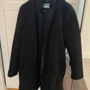 Svart teddyjacka Noisy may - Mysig svart teddyjacka perfekt för kalla dagar. Den har en långärmad design och är gjord av mjukt material som håller dig varm och bekväm. Jackan är i bra skick och passar perfekt för både höst och vinter. Ett måste för garderoben!