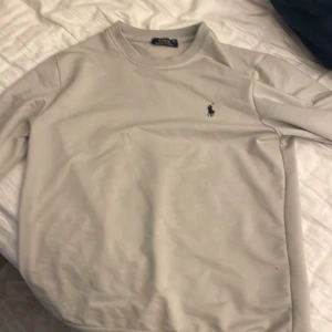 Beige tröja från Polo Ralph Lauren - Säljer en tunn  men stilren beige sweatshirt/tröja från Polo Ralph Lauren. Den har en klassisk design med långärmade ärmar och det ikoniska logotypbroderiet på bröstet. Perfekt för både vardag och lite finare tillfällen. Passar bra till jeans eller chinos!