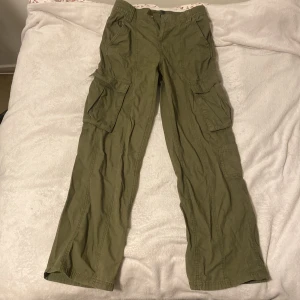 Olivgröna cargobyxor från H&M Divided - Säljer ett par olivgröna cargobyxor från H&M Divided i storlek XS. Byxorna har flera praktiska fickor och en loose passform, perfekt för en avslappnad stil. De är i bra skick och passar utmärkt för höst och vår. Säljer då jag ej använder dom längre 💋