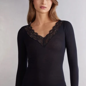 Svart långärmad topp med spetsdetaljer - Säljer min jätte snygga intimmisimi tröja som jag säljer för att jag inte tycker att jag passar så bra i den!❤️. Perfekt för både vardag och fests