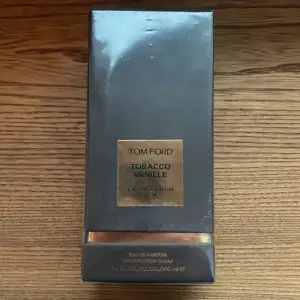 Säljer en lyxig Tom Ford Tobacco Vanille Eau de Parfum, 100 ml. Den kommer i en elegant mörkbrun förpackning med guldiga detaljer. Perfekt för den som älskar en varm och kryddig doft med inslag av tobak och vanilj. Helt ny och oöppnad!