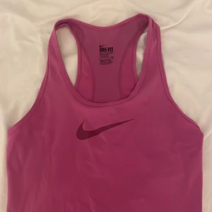 Rosa Dri-FIT linnetopp från Nike - Säljer en rosa Dri-FIT linnetopp från Nike i storlek S. Perfekt för träning.  Superbekväm och sällan använt