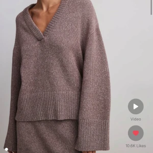 Brun stickad tröja - Mysig brun/lila  stickad tröja med v-ringning och långa ärmar. Perfekt för kyliga dagar med sin avslappnade passform och ribbade detaljer vid ärmslut och nederkant. En stilren och bekväm tröja för både vardag och mysiga stunder hemma.