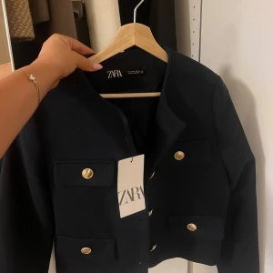Svart kavaj från Zara - Snygg svart kavaj från Zara med guldknappar. Har aldrig använt den. 