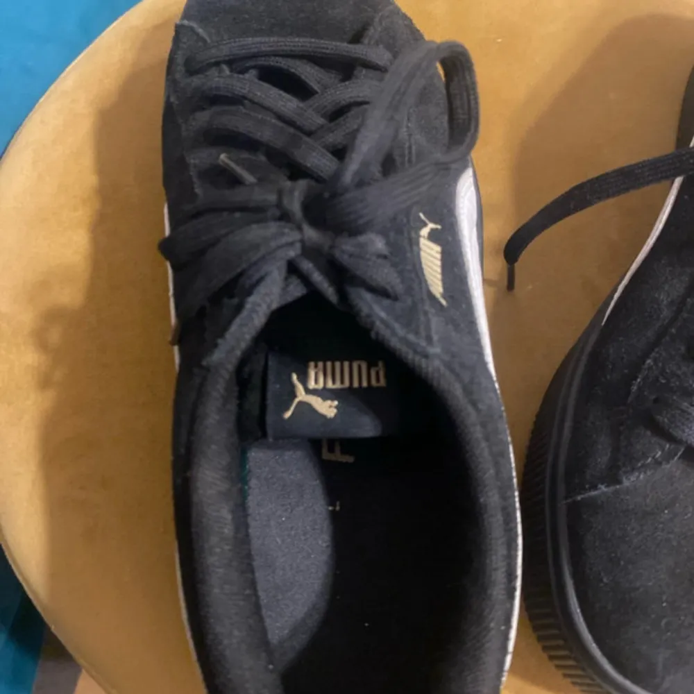 Säljer ett par snygga svarta sneakers från Puma i bra skick. De är gjorda av mocka och har klassisk snörning. Perfekta för vardagsbruk och passar till nästan allt. Sulan är i bra skick och de har en stilren design med Pumas logga på sidan.. Skor.