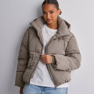 Beige pufferjacka - Säljer en supermysig beige pufferjacka som är perfekt för kalla dagar. Jackan har en dragkedja framtill och en stor, gosig huva. Den är i mycket bra skick och passar perfekt för både höst och vinter. Jackan har en normal passform och är långärmad. Perfekt för att hålla sig varm och snygg! 🧥✨