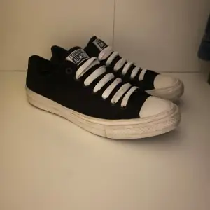 Säljer ett par klassiska svarta Converse All Star sneakers i bra skick. De har vit snörning och en vit sula som ger en snygg kontrast. Perfekta för vardagsbruk och passar till nästan alla outfits. Storleken 43, men passar även 44! Hör av dig vid frågor o funderingar!