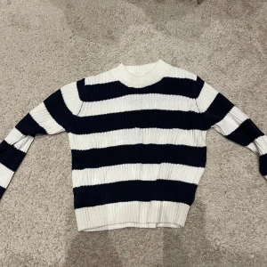 Randig stickad 💝 - Säljer en superfin randig stickad tröja i mörkt blått och vit. Perfekt för att hålla sig varm och stilen!❄️