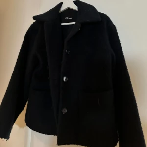 Mörkblå jacka från Monki - Säljer en mörkblå jacka från Monki i mycket bra skick. Den har en klassisk design med knappar framtill och stora fickor. Perfekt för höst och vår, och den är både stilren och bekväm.