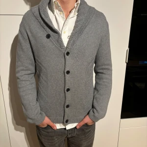 H&M kofta grå M - Grå kofta från märket H&M, storlek M. Bra använt skick, inga defekter. Modell på bild är 182/67kg. Hör av dig vid eventuella frågor! Mvh CAVI