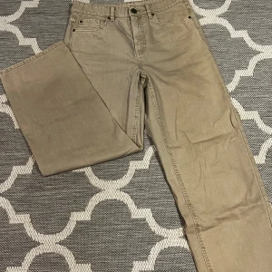 Beige jeans från Denim 1953 - Säljer ett par snygga beige jeans från Denim 1953 i storlek 38. De har en klassisk femficksdesign och är perfekta för både vardag och fest. Jeansen är i bra skick och har en normal passform. Perfekta för höst och vår!
