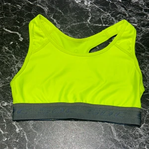 Neongul sport-bh från SOC - En snygg neongul sport-bh från SOC i storlek 34. Den är använd ett fåtal gånger för några år sedan men är i fortfarande i väldigt bra skick. Säljer då den är för liten för mig. 
