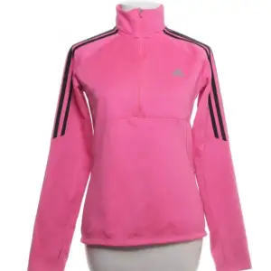 Säljer en snygg rosa träningströja från Adidas med svarta ränder på ärmarna. Perfekt för träning eller en sportig vardagslook. Jackan har en halv dragkedja och hög krage för extra komfort. Den är knappt använd men osäker på storleken då lappen är borta  men skulle gissa på M-L då jag har vanligtvis M och passar bra på mig men inte tajt.