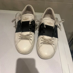 Valentino Open - Säljer ett par snygga Valentino sneakers i vitt med svarta detaljer. De har en cool design med snörning och är i bra skick. Perfekta för både vardag och festliga tillfällen. Passar till det mesta i garderoben! Storlek 41,5 men Lasse även 42-42,5. Priset är ej hugget i sten!