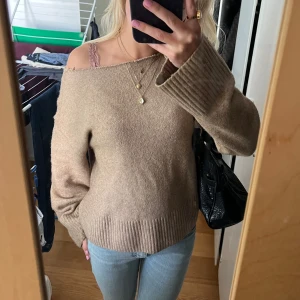 Beige offshoulder tröja från & Other Stories - Säljer en superfin beige offshoulder tröja från & Other Stories som jag klippt själv. Den är perfekt för höst och vår. Tröjan har långa ärmar och en loose passform som gör den bekväm. Mycket bra kvalitet! Pris går att diskuteras 🫶🏻