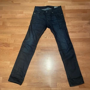 Marinblåa jeans från Diesel - Säljer ett par marinblåa jeans från Diesel, modell Darron (slim/straight). De har en snygg passform och är i storlek W29 L32 men passar W29 L34. Jeansen är i bra skick och har en najs wash. Perfekta för både vardag och fest!
