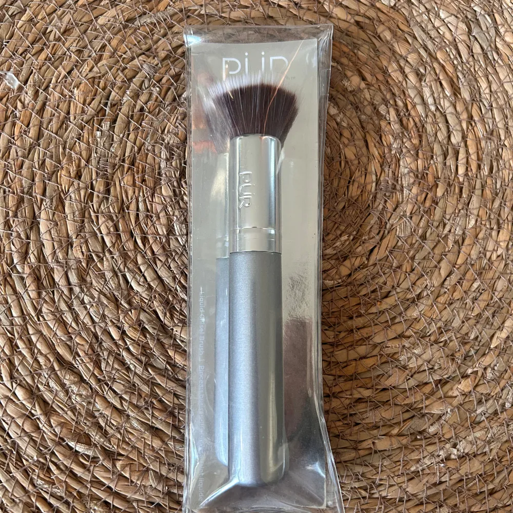 Säljer en Liquid Chisel Brush från PÜR, perfekt för att applicera flytande foundation. Borsten har ett stilrent silverfärgat handtag och täta, mjuka borst som ger en jämn och fin finish. Den är fortfarande i sin originalförpackning. Perfekt för dig som vill ha en professionell look! Nypris 450 kr🪩🤍. Skönhet.