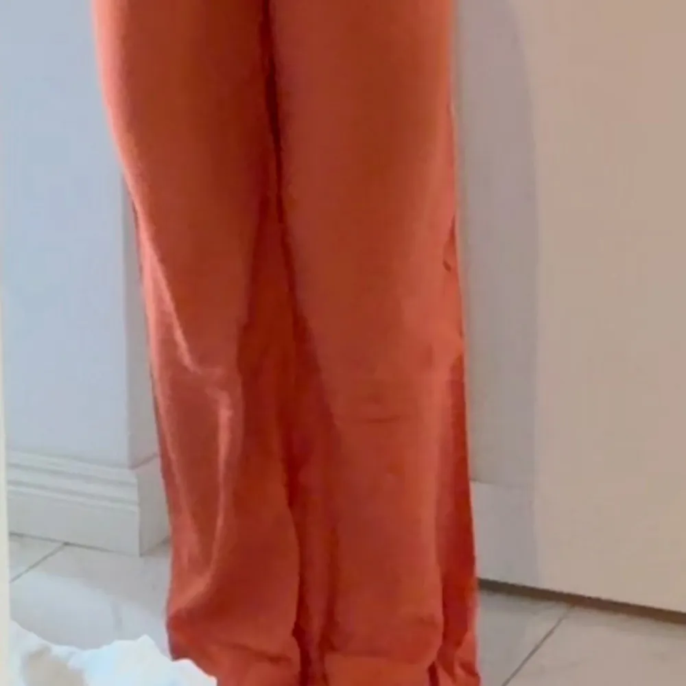 Säljer ett par snygga orange byxor från Madlady. De är högmidjade och har en loose passform med vida ben. Perfekta för en somrig look eller en färgglad höstoutfit. Materialet känns lätt och bekvämt, vilket gör dem idealiska för både vardag och fest.. Jeans & Byxor.