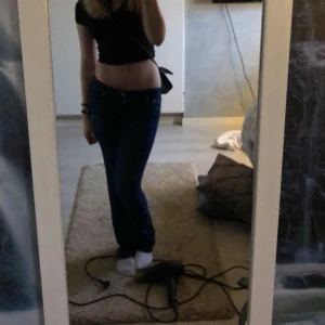 Lågmidjade jeans  - Ett par skitsnygga mörkblå lågmidjade jeans från Nelly. Slitningar där nere:) 