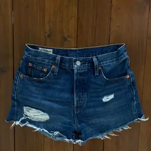 Mörka Levis shorts med knappar. 