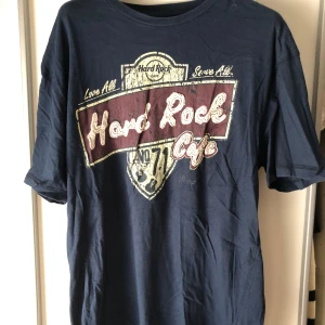 Blå Hard Rock Cafe t-shirt - Säljer en blå Hard Rock Cafe t-shirt i storlek XL men sitter som M/L. Väl använd.  