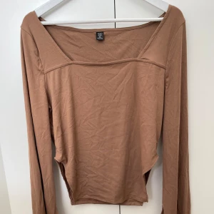 Brun tröja med fina detaljer  - Brun tajt tröja från shein med detaljer vid armar samt höften. Storlek 3XL men skulle säga att den sitter mer som en XL. Är aldrig använd 