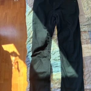Svarta Levis 502 jeans - Säljer ett par svarta Levis 502 jeans i storlek W30. De är i bra skick och har en klassisk design med fyra fickor och knappgylf. Perfekta för både vardag och fest!🥂