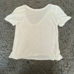 Vit kortärmad t-shirt - Säljer en vit kortärmad t-shirt. Den är enkel och stilren, perfekt för vardagsbruk. T-shirten är i bra skick och passar till det mesta. Perfekt för sommaren eller som basplagg i garderoben.
